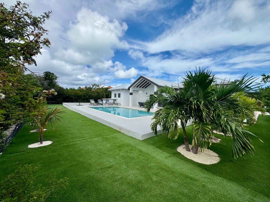 Beautiful exterior view of Blue Water Villa with private swimming pool, lush gardens, and outdoor spaces.