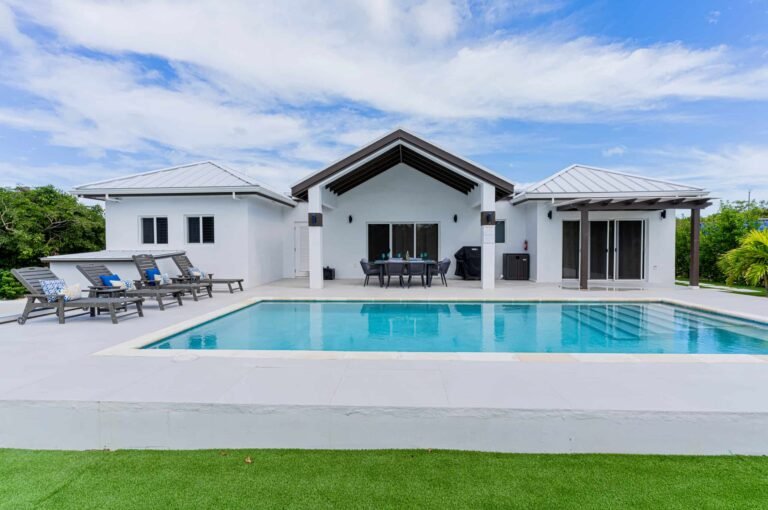 Spacious private swimming pool with luxury villa and outdoor lounge area at Blue Water Villa.